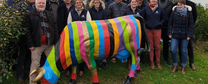 Les techniciens Prim'Holstein de Gènes Diffusion autour d'une vache décorative