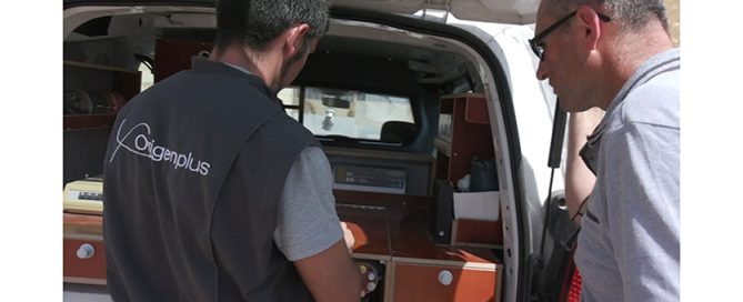 Un technicien inséminateur et un éleveur près d'une caisse d'un technicien inséminateur